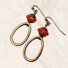 Hoop earrings in copper with burnt orange Czech glass beads. Sophisticated minimalist dangle earrings, lightweight and comfortable for all day wear. Fabulous fall earrings in a trending color. Stunning Saturn beads are capped with a copper finish. Artisan glass beads produced in small quantities in the Czech Republic. Hypoallergenic ear wires (nickel and lead free). Select ear wire style at checkout. A gift for you or someone special, earrings are carded and in an organza bag. Link back to my sh Brown Metal Hoop Earrings, Rust-colored Earrings For Gift, Bronze Dangle Hoop Earrings With Ear Wire, Brown Metal Hoop Jewelry, Vintage Copper Dangle Hoop Earrings, Copper Beaded Drop Earrings With Ear Wire, Rust Dangle Earrings With Ear Wire, Rust Color Dangle Earrings With Ear Wire, Orange Copper Dangle Earrings