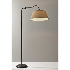 a floor lamp with a brown shade on the base and a white light behind it