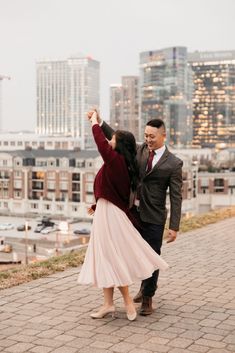 a man and woman dancing in front of the city skyline