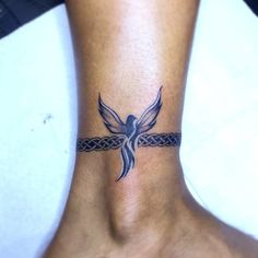 a woman's foot with a tattoo on the ankle that has a bird on it