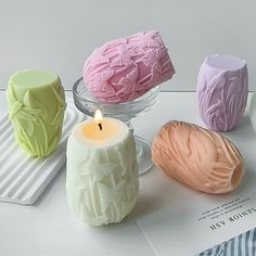 four different colored candles sitting on top of a table