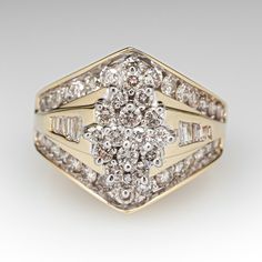 This elegant ring is centered with a cluster setting accented with forty-six (46), prong set, round brilliant cut diamonds. The ring is also accented with thirty (30), bead set, round brilliant cut diamonds and twelve (12), channel set, baguette cut diamonds. The ring measures 10.8mm at the top, rises 4.9mm above the finger, tapering to 4.2mm wide and 1.1mm thick at the base of the shank. This ring is currently a size 7.25. Diamond Cluster Ring In Fine Jewelry Style, Luxury Brilliant Cut Cluster Ring, Yellow Gold Cluster Halo Ring, Diamond White Cluster Diamond Ring, Dazzling Diamond Cluster Ring With Single Cut Diamonds, Luxury Cluster Ring With Prong Setting, Dazzling Cluster Diamond Ring With Single Cut Diamonds, Fine Jewelry Diamond Ring With Single Cut Cluster, Cluster Pave Setting Promise Ring