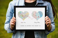 a woman holding up a framed poster with two heart shaped balloons in the shape of hearts