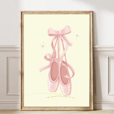 a pink ballet shoe with a bow hanging on the wall