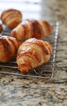 some croissants are sitting on a cooling rack