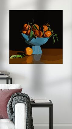 a blue bowl filled with oranges sitting on top of a table next to a white couch