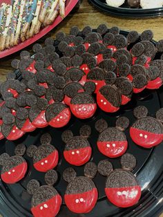 mickey mouse cupcakes and cookies are arranged on black trays with red frosting