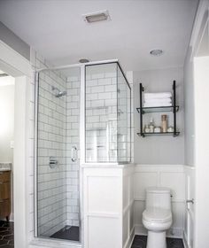 a white toilet sitting next to a walk in shower