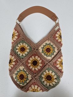 Handmade, Crocheted,  Across the body/shoulder bag. Can be used as either an across the body or a shoulder bag. As you may already have a Strap of your own I offer this handmade bag in a choice of 2 options:- 1. Canvas Across Body Strap 2. Brown Faux Leather Shoulder Strap 3. No strap required; will have small eyelets attached for strap to be added. Main body colour is Taupe with different colour centres per square. Width of bag is approximately 30cm. Length from middle V is approximately 24 cm. Brown Crochet Hobo Bag For Everyday Use, Brown Hobo Crochet Bag For Everyday, Brown Crochet Tote Bag With Granny Square, Beige Granny Square Bag For Daily Use, Beige Granny Square Shoulder Bag For Everyday, Brown Granny Square Crochet Tote Bag, Everyday Beige Shoulder Bag With Granny Square, Square Brown Crochet Bag For Everyday Use, Brown Square Crochet Bag For Everyday Use