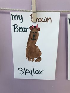 two children's handprints hanging from clothes pins on a rope with the words, my brown bear and skylarr