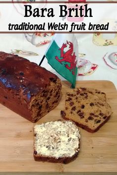 a loaf of bread sitting on top of a wooden cutting board next to two slices of cake