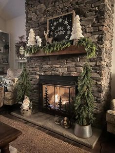 a fireplace decorated for christmas with evergreens and pine cones on the mantel above it