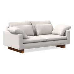 a white couch with two pillows on it's back and the arms folded down