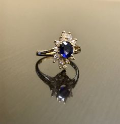 DeKara Designs Clearance Metal- 14K Yellow Gold, .583. Stones- 1 Oval Ceylon Blue Sapphire 0.80 Carats, 4 Marquise Diamonds G Color VS1 Clarity 0.40 Carats, 8 Round Diamonds H Color VS1 Clarity 0.20 Carats. Size- Ring is a 6 3/4, and could be sized up or down at no additional cost! FREE SIZING Handmade 14K Yellow Gold Ceylon Blue Sapphire Halo Diamond Ring. This ring is inspired by the Art Deco era with an enticing fiery oval shaped Ceylon Blue Sapphire. The sapphire is set in between 4 prongs. Blue Diamond Cluster Ring For Formal Occasions, Luxury Blue Marquise Cut Ring, Blue Marquise Cut Diamond Jewelry, Blue 14k Gold Rings For Anniversary, Blue Cluster Ring For Formal Occasions, Formal Blue Diamond Cluster Ring, Formal Blue Cluster Ring, Blue Sapphire Ring With Halo Setting In 14k Gold, Blue 14k Gold Diamond Ring With Halo Design