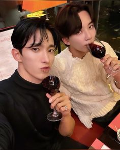 two people sitting at a table drinking wine