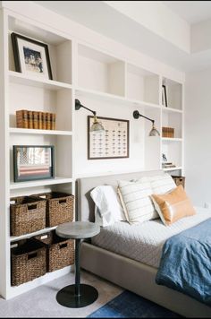 a bedroom with white bookcases and blue carpet