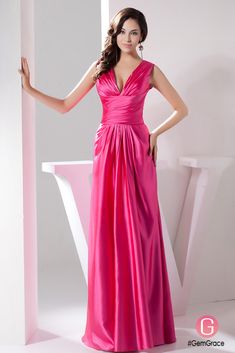 a woman in a long pink dress posing for the camera with her hands on her hips