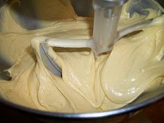 a mixing bowl filled with batter on top of a wooden table