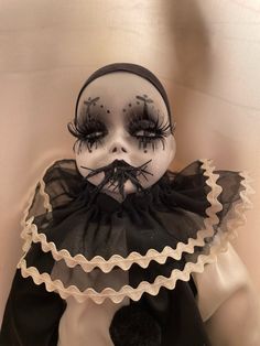 a doll with black and white makeup on it's face