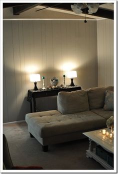 a living room filled with furniture and two lamps on top of each other's tables