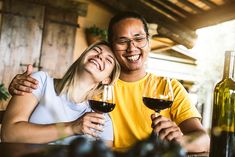 a man and woman sitting at a table with wine glasses