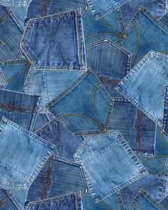 many blue jeans are stacked together on top of each other, with yellow stitchs