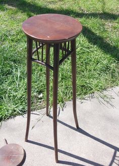 a small table sitting on top of a cement ground next to a grass covered field