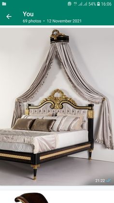 a bed with a canopy over it and pillows on the bottom side, in front of a white wall