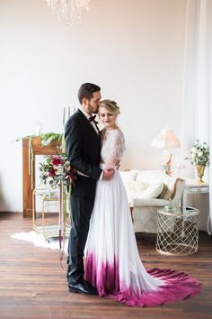 a bride and groom standing in front of a chandelier