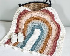 a crocheted blanket and pair of white baby shoes