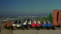 there are many pairs of shoes lined up on the ledge in front of a city