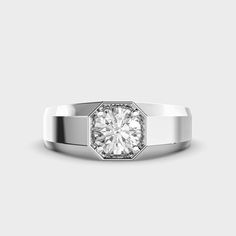 a white gold ring with a round diamond in the center, on a gray background