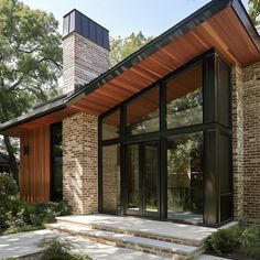 a modern house with large windows and stone steps