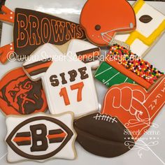 decorated cookies are arranged in the shape of footballs, helmets, and sports jerseys