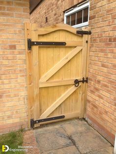 an open wooden gate on the side of a brick building