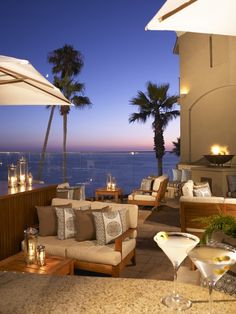 a living room filled with furniture next to a fire place covered in candles and palm trees