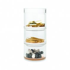 three tiered glass container filled with gold and black marbles on top of each other