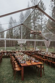 an outdoor tent with tables and chairs set up for a wedding reception in the rain