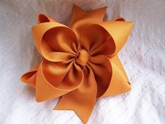 an orange bow on top of a white blanket