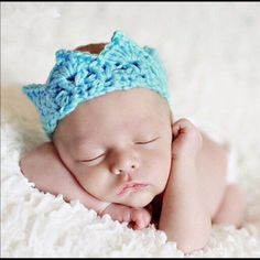 a newborn baby wearing a crocheted blue hat