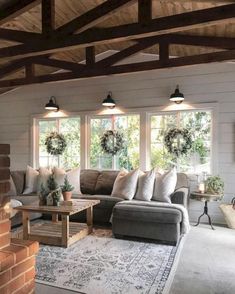 a living room filled with furniture and windows covered in wreaths on top of them