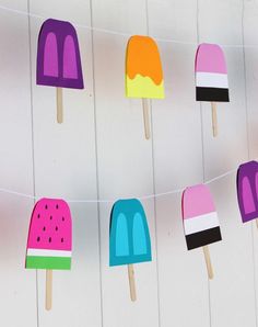 popsicles are lined up on a line with watermelon and ice cream sticks