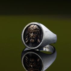 "Are you looking for a unique and meaningful piece of Christian jewelry? Check out this stunning Jesus Ring! Crafted with love and precision by a skilled jeweler, it features a Sterling silver signet ring adorned with a beautiful bronze Jesus Christ head.This exquisite ring not only makes a stylish statement but also serves as a symbol of faith and devotion. It's perfect as a Christmas gift, a reminder of the true meaning of the holiday. The combination of Sterling silver and bronze creates a ca Antique Oxidized Finish Signet Ring For Gift, Antique Oxidized Finish Signet Ring As Gift, Bronze Engraved Rings For Gift, Bronze Engraved Rings Ideal For Gifts, Antique Oxidized Finish Engraved Ring As Gift, Engraved Bronze Rings Ideal For Gifts, Engraved Bronze Rings Gift, Unique Brass Signet Ring For Gift, Vintage Oxidized Signet Ring For Gift