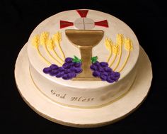 a cake decorated with grapes and a chalicee on top that says god mess