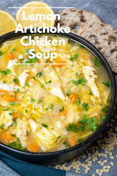 lemon artichoke chicken soup in a black bowl with bread and parsley on the side