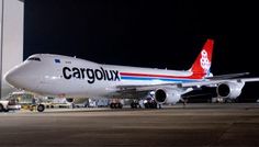 an airplane parked in front of a building at night