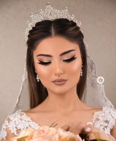 a woman wearing a tiara and holding a bouquet