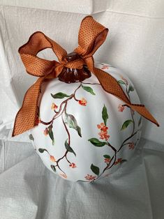 a white pumpkin decorated with an orange bow