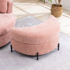 a living room with two pink couches and a potted plant on the floor