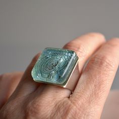 Chunky aqua green statement ring made for the bold and brave. This ring has an amazing and magical depth in the glass.  Measurements: 20 mm x 20 mm (0.8" x 0.8"). The ring band is adjustable size and made of silver plated brass.  The ring will arrive nicely packaged ready to give as a gift. Handmade from recycled window glass of buildings in beautiful Barcelona in Spain, a perfect gift for someone who cares about the environment. The hand painted flower decor is placed inside the glass and the t Modern Glass Rings Suitable For Gifts, Handmade Green Rings With Recycled Glass, Handmade Glass Rings For Gift, Aqua Green Color, Recycled Window, Glass Ring, Painted Flower, Friend Gifts, Window Glass